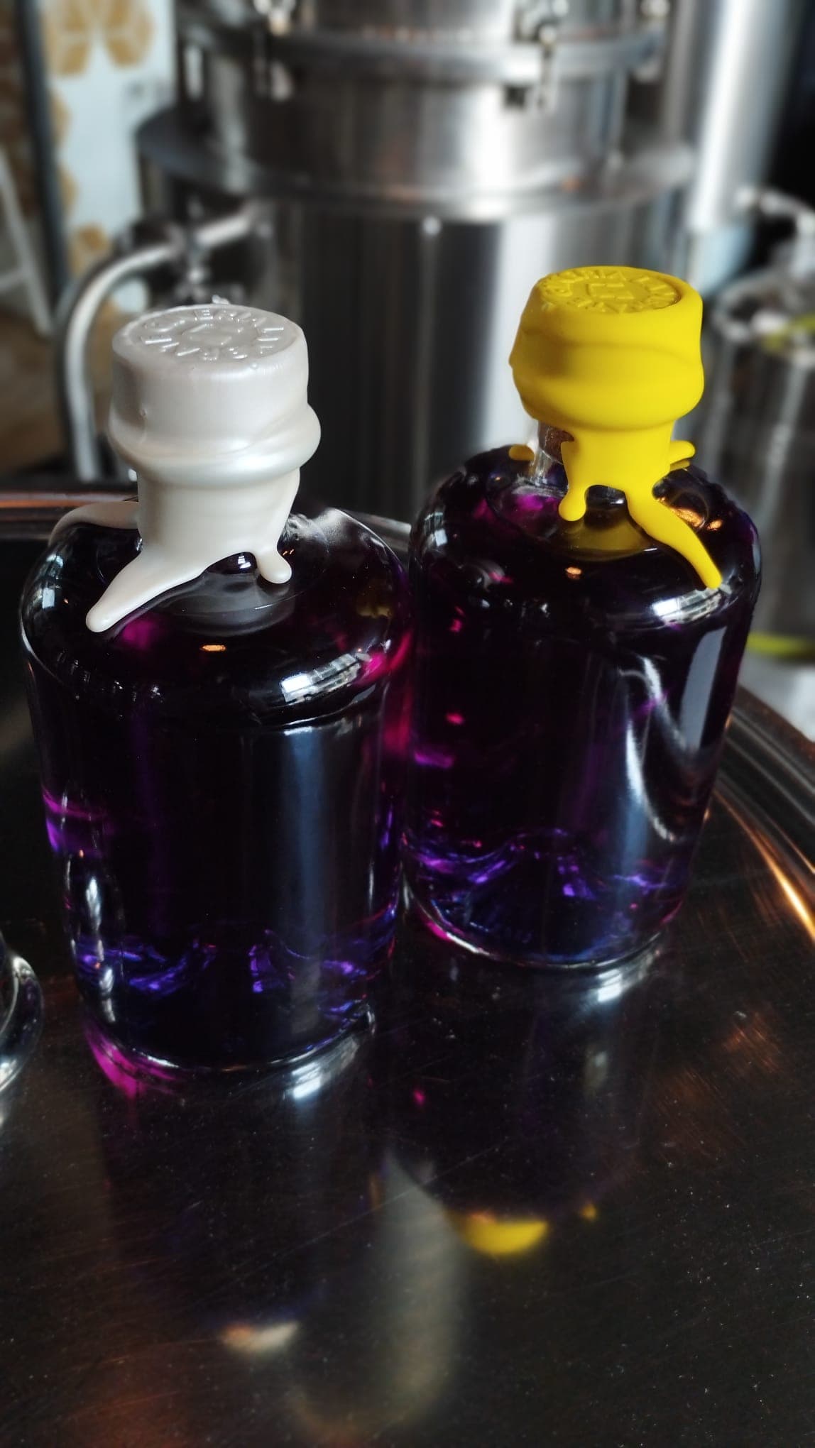 Due bottiglie di gin appena imbottigliate, con ceralacca bianca e gialla